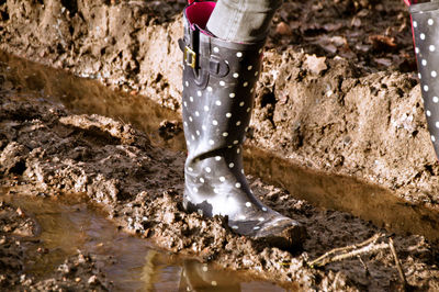 Low section of woman walking on dirt road