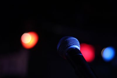 Close-up of microphone with stage lights in the background 