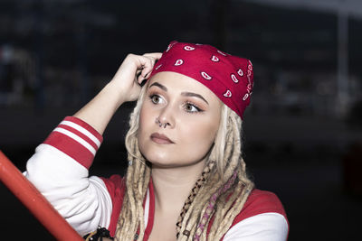 Blonde woman with dreadlocks leaning on one hand