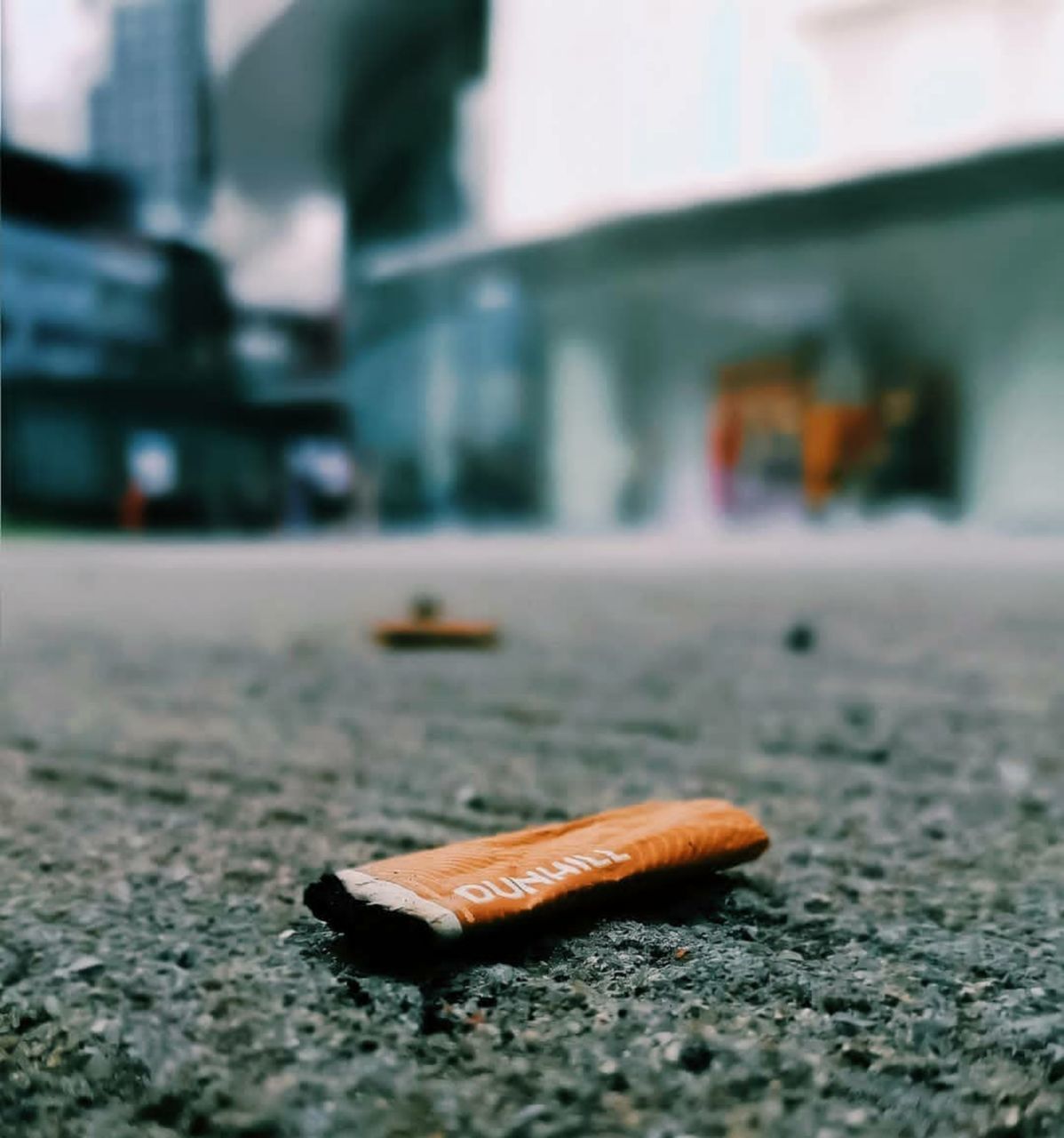 SURFACE LEVEL OF CIGARETTE ON STREET IN CITY