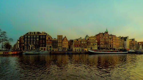 Boats in river with buildings in background