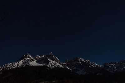 Scenic view of snowcapped mountains against sky at night