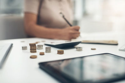 Midsection of woman counting coins at office