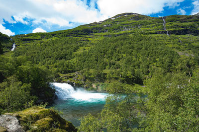 Scenic view of waterfall against sky