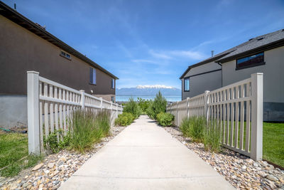 Footpath amidst buildings against sky