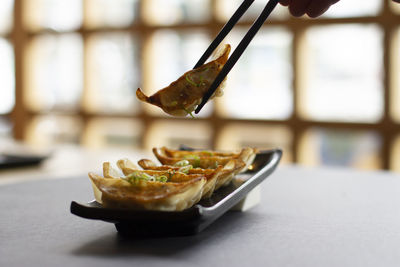 Dumpling eaten with chopsticks in authentic asian restaurant