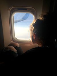 Man sitting in airplane window