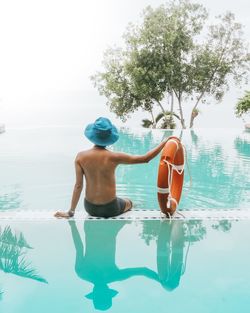 Full length of shirtless man swimming in pool