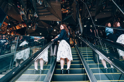 High angle view of woman standing on escalator