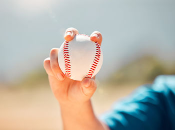 Midsection of woman holding baseball