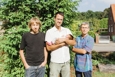 Portrait of family standing against plants