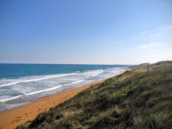 Scenic view of beach against blue sky