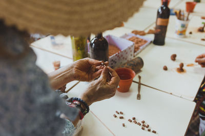 Old woman, teacher showing how to do pottery to students on a workshop. canary culture