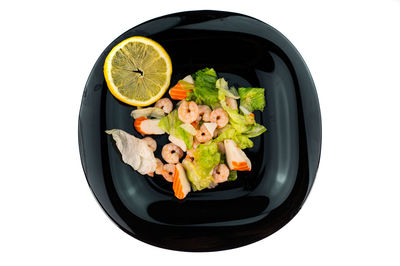 Close-up of fresh fruits in plate against white background