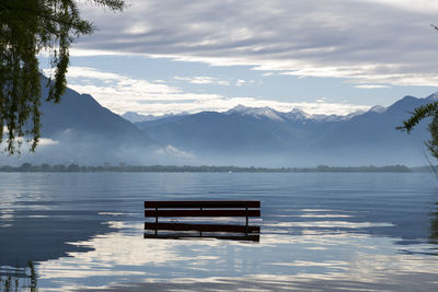 Bench in lake maggiore against mountains