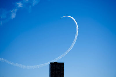 Low angle view of vapor trail against blue sky