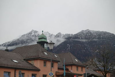 Houses on snowcapped mountain against sky