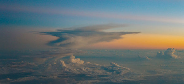 Scenic view of sea against dramatic sky during sunset
