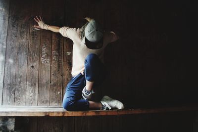 Full length of woman sitting on wooden floor