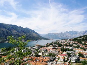 Town by lake and mountains against sky