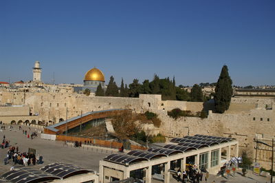 Group of people in front of historic building against clear sky