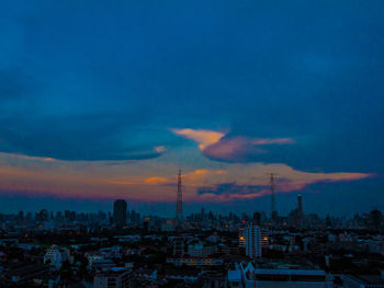 Aerial view of cityscape against cloudy sky