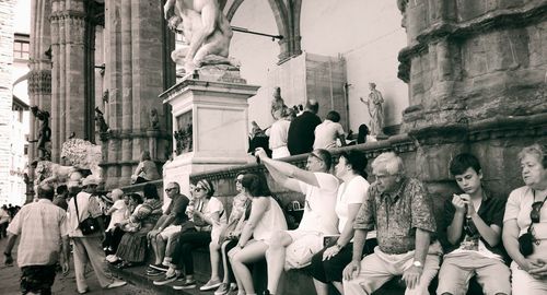 People standing on street against buildings in city