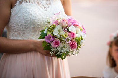 Close-up of woman holding bouquet of pink flower