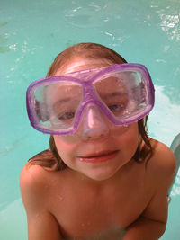 High angle portrait of girl with swimming goggles by swimming pool