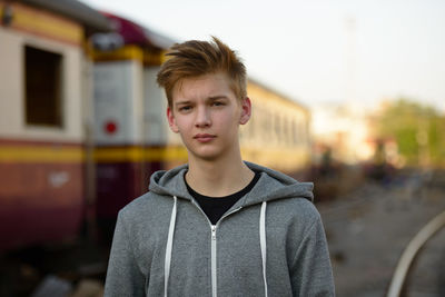 Portrait of young man standing in city
