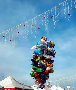 Low angle view of carousel hanging in amusement park against sky