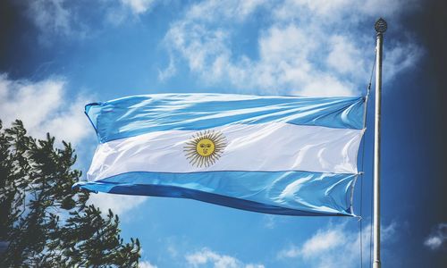 Low angle view of flag against blue sky