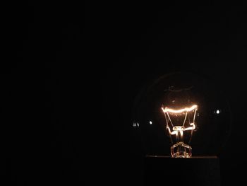 Low angle view of illuminated lamp at night