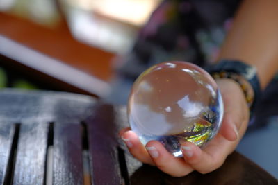 Close-up of hand holding crystal ball