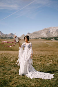 Full length of woman standing on land against sky