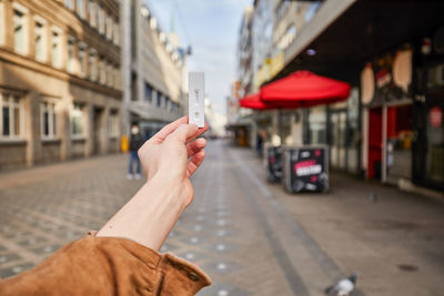 Midsection of man using smart phone on street