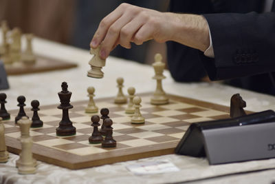 Midsection of man playing on chess board