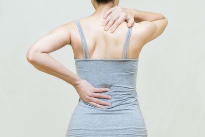 Rear view of young woman standing against white background