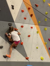 A girl has a fun by sport climbing on a wall
