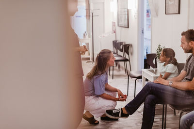 Female pediatrician talking with patient at hospital corridor