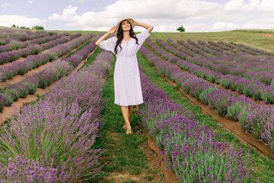 Close up of beautiful smiling woman in hat enjoying summer in lavender field 