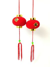 Close-up of red bell hanging against white background