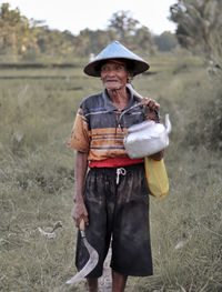 Man holding umbrella while standing on field