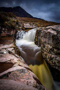 Scenic view of waterfall against sky