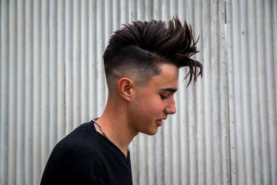 Portrait of young man looking away against wall