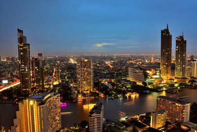 Illuminated cityscape against sky at night