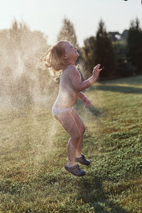 Cheerful shirtless girl enjoying at yard