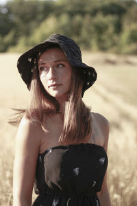 Woman wearing hat standing on field