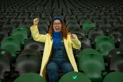 Portrait of woman with arms raised