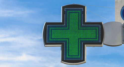 Low angle view of illuminated sign against sky